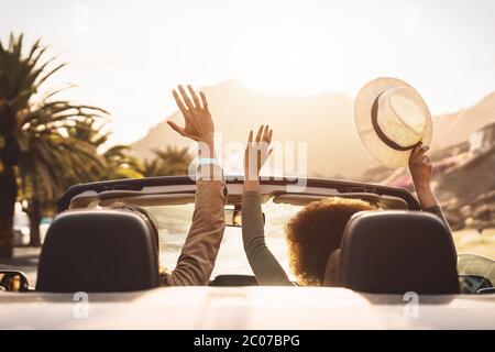Glückliches junges Paar macht einen Ausflug in die tropische Stadt - Reisen Sie Leute, die Spaß haben, mit dem trendigen Cabrio-Auto zu fahren und neue Orte zu entdecken Stockfoto