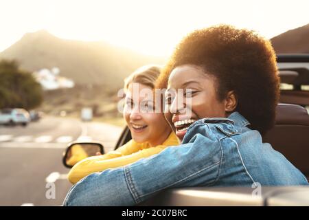 Glückliche Mädchen tun Roadtrip in tropischen Stadt - Reisen Menschen Spaß beim Fahren in trendigen Cabrio Auto entdecken neue Orte Stockfoto