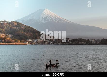 Zwei Fischer fischen auf einem kleinen Boot am Kawaguchi See vor dem Fuji Berg in Kawaguchiko Japan Stockfoto