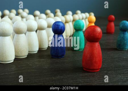 Konzept der Einbeziehung und Diskriminierung. Linien von Holzfiguren und verschiedene als Symbol der Vielfalt. Stockfoto