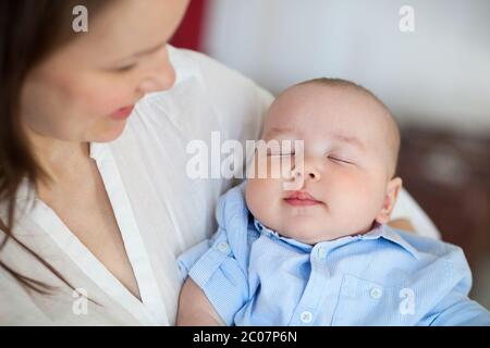 Baby Boy beim Einschlafen in den Armen der Mutter Stockfoto