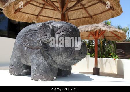 Die Statue des Oriental Stone Pig befindet sich vor einem japanischen Teriyaki-Restaurant in der Sonne Mexikos Stockfoto