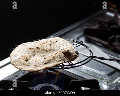 Traditionelle Art und Weise der Herstellung von indischen Roti / Chapati / Tava Roti, in indischen Haushalt. Stockfoto