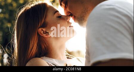 Kaukasische Dame mit roten Haaren und Sommersprossen umarmen ihren Geliebten im Licht der Sonne und küssen Stockfoto