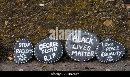 Port Seton, East Lothian, Schottland, Großbritannien. Juni 2020. Covid-19 Pandemiesymbole von Einheimischen: Eine hunderte Meter lange Linie an der Strandpromenade mit bunten und kreativen handbemalten Steinen mit inspirierenden Botschaften. Es scheint ein Phänomen zu sein, das sich in den Städten und Dörfern von East Lothian verbreitet. Black Live Matter, Stop Rassismus und George Floyd Steine Stockfoto