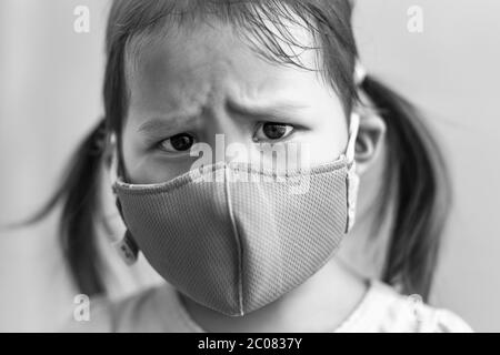 Das kleine Kind trägt eine Maske, um sich vor der giftigen Luftverschmutzung in asien zu schützen. Stockfoto