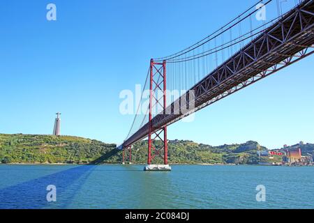 25 de Abril Hängebrücke, die die Stadt Lissabon mit der Gemeinde Almada und der Statue Christi im Hintergrund verbindet, Portugal. Stockfoto