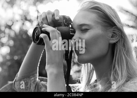 Eine hübsche blonde Frau, die im Freien ein Foto gemacht hat. Vintage-Stil schwarz und weiß. Altmodisch. Stockfoto