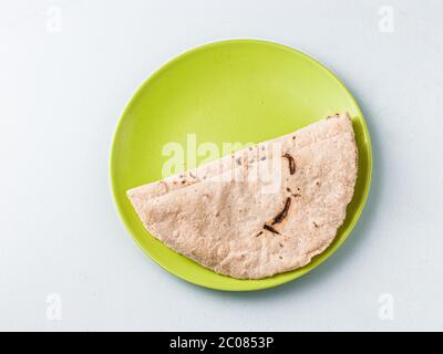 Chapati / Tava Roti/ Roti auch bekannt als Indisches Brot oder Fulka/Phulka. Hauptbestandteil des Mittagessens/Abendessens in Indien. Dekoriert und in einer grünen Farbe serviert Stockfoto