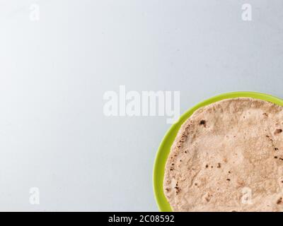 Chapati / Tava Roti/ Roti auch bekannt als Indisches Brot oder Fulka/Phulka. Hauptbestandteil des Mittagessens/Abendessens in Indien. Dekoriert und in einer grünen Farbe serviert Stockfoto