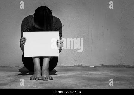 Nahaufnahme einer isolierten armen Frau mit einem weißen Schild auf der Straße Stockfoto