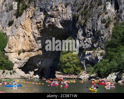 Kanus mit Kanufahrern auf dem Ardeche Fluss in der Nähe des Bogens von Vallon Pont d'Arc , Ardeche Department, Auvergne-Rhone-Alpes, Frankreich, Europa Stockfoto