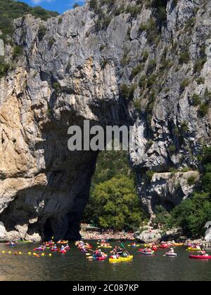 Kanus mit Kanufahrern auf dem Ardeche Fluss in der Nähe des Bogens von Vallon Pont d'Arc , Ardeche Department, Auvergne-Rhone-Alpes, Frankreich, Europa Stockfoto