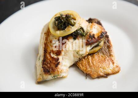 Zwei frittierte Filets aus einem Bass, Dicentrarchus labrax, die in der Nacht Strand Angeln mit Rute und Linie gefangen wurde. Die Filets wurden in Olive oi gebraten Stockfoto