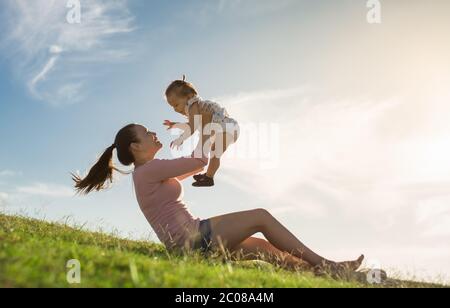 Eine Familie, die im Park spielt, Spaß hat, zusammen zu lachen und zu lächeln. Stockfoto