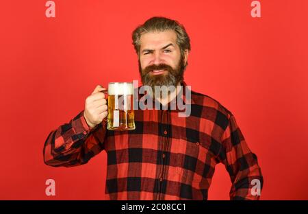 Oktoberfest. Bierkneipe. Stilvoller Barkeeper oder Barkeeper in der Bar. Erholung. Mann halten ein Glas Bier. Hipster an der Bar Zähler. Spaß beim Fußball beobachten. Brutal bärtiger Mann trinkt Bier aus Glas. Stockfoto