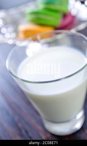 Milch im Glas und Farbe Makronen Stockfoto