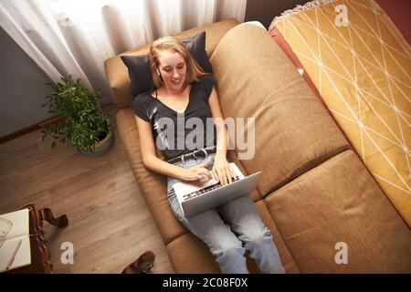 Junge Frau, die von zu Hause aus auf dem Sofa entspannt. Stockfoto