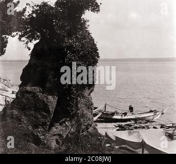 [ 1900er Japan - Japanisches Fischerboot ] - EIN japanischer Fischer, der an seinem Fischerboot arbeitet, Anfang 1900er Jahre. Rechts werden Netze ausgelassen, um in der Sonne zu trocknen. Silberdruck mit Vintage-Gelatine aus dem 20. Jahrhundert. Stockfoto