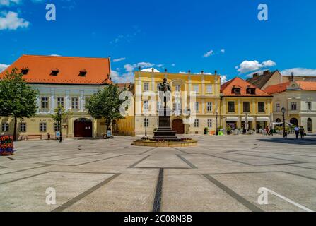 Blick auf den Wiener Torplatz in Gyor, in der Mitte die Skulptur des berühmten ungarischen Schriftstellers Karoly Kisfaludy und um ihn herum die gemütlichen alten Gebäude. Stockfoto