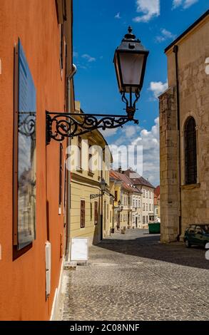 Blick auf die Straße von Gyor, Ungarn. Barockhäuser, typische gepflasterte schmale Straße. Stockfoto