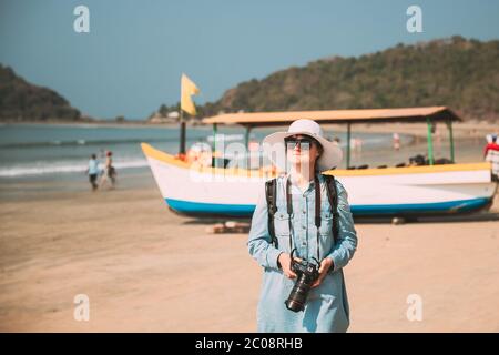 Canacona, Goa, Indien. Junge Kaukasische Dame Frau Mit Kamera Steht Am Berühmten Palolem Strand In Der Nähe Des Arabischen Meeres Im Sommer Sonnentag Stockfoto