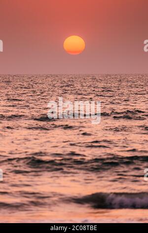Natürliche Farbe Sonnenuntergang Sonnenaufgang Himmel Über Meer. Seeslandschaft Mit Strahlender Sonne Am Meereshorizont Stockfoto