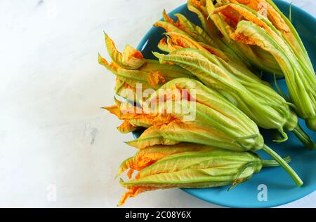 Zucchini Blumen in einer blauen Schale isoliert auf weißem Hintergrund. Nahaufnahme. Stockfoto