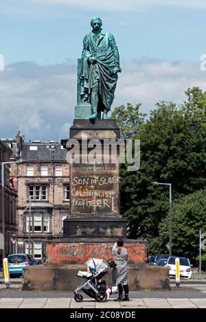 Frau mit Kind hält an, um die Graffiti auf der Statue von Robert Dundas, 2. Viscount Melville, in Edinburgh, Schottland, Großbritannien zu fotografieren. Stockfoto