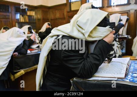 Jüdische Gläubige bedecken ihre Augen während der Morgengebete. Im Büro von Rebbe am Hauptsitz von Lubavitch in Crown Heights, Brooklyn, New York. Stockfoto