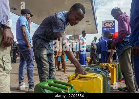 Simbabwer stellen sich an, um an einem Bahnhof in Harare, der Hauptstadt, Kraftstoff zu sammeln. (Linda Mujuru, GPJ Simbabwe) Stockfoto