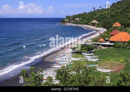 Jemeluk Strand und Jukungboote an sonnigen Tagen in Bali, Indonesien. Amed ist ein beliebtes Touristenziel geworden und liegt an der Ostküste von Bali Stockfoto