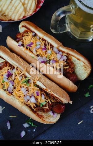 Hausgemachte Chili Hunde mit Cheddar-Käse gekrönt, selektive Fokus Stockfoto