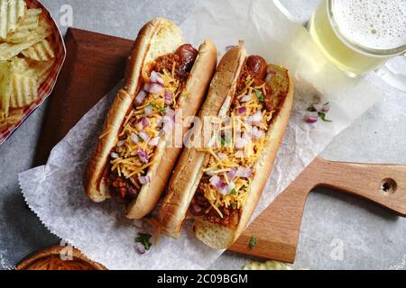 Hausgemachte Chili Hunde mit Cheddar-Käse gekrönt, selektive Fokus Stockfoto