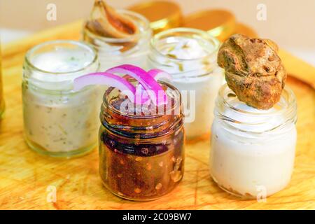 Italienische Vorspeisen, Trüffelbutter, Sardellenbutter, aromatische Kräuterbutter, Artischocken in Öl, eingelegte Gurken, süße und saure Zwiebeln, Zwiebelmarmelade. Stockfoto