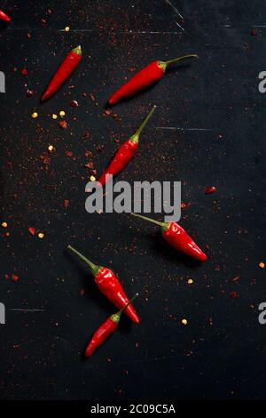 Getrocknete ganze Chilis und Chilischoten auf schwarzer Tischplatte Stockfoto