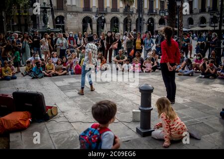 11. Juni 2020, Barcelona, Katalonien, Spanien: Nachbarn des Gotischen Viertels treffen sich bei einer Straßentheatershow am normalerweise belebten Touristenhochpunkt Plaza Real in Barcelona. Während die allmähliche Dekonfinement geht weiter, Barcelonier genießen Orte der Stadt, die von Touristen vor Coronavirus Pandemie Krise gefüllt wurden. Europäische Union fordert Öffnung der Binnengrenzen bis zum 15. Juni will die spanische Regierung bis zum 1. Juli warten. Quelle: Jordi Boixareu/Alamy Live News Stockfoto