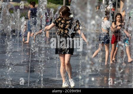 Moskau, Russland. 11. Juni 2020 EIN junges Mädchen badet in einem Brunnen im Muzeon Park auf der Krymskaja Böschung während der ungewöhnlich heißen Wetter in Moskau, Russland. Am 11. Juni erreichte die Temperatur in Moskau bis zu 30 Grad Stockfoto