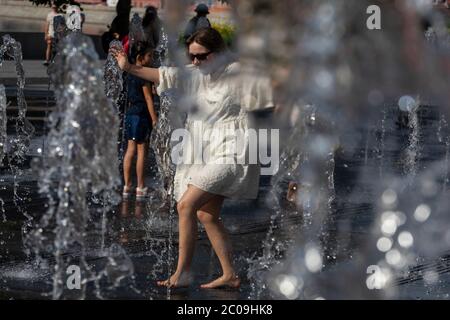 Moskau, Russland. 11. Juni 2020 EIN junges Mädchen badet in einem Brunnen im Muzeon Park auf der Krymskaja Böschung während der ungewöhnlich heißen Wetter in Moskau, Russland. Am 11. Juni erreichte die Temperatur in Moskau bis zu 30 Grad Stockfoto