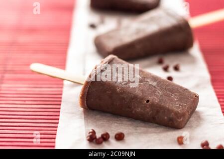 Rote Adzuki Bohnen, Eiszapfen. Eisdielen sind eine köstliche Art, sich an heißen Sommertagen abzukühlen, diese bestehen aus rotem Adzuki-Bohnen-Eis, einem winzigen asiatischen Su Stockfoto