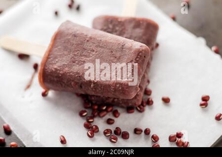 Gefrorene Adzuki Bohnen Popsicle. Eisdielen sind eine köstliche Art, sich an heißen Sommertagen abzukühlen, diese bestehen aus rotem Adzuki-Bohnen-Eis, einem winzigen asiatischen Stockfoto