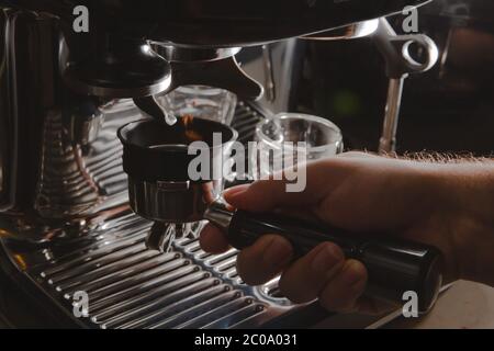 Nahaufnahme der Hand-Mahlmaschine eines Barista, die Kaffeebohnen zum Brühen von Espresso mahlen, Nahaufnahme der manuellen Espressomaschine Stockfoto