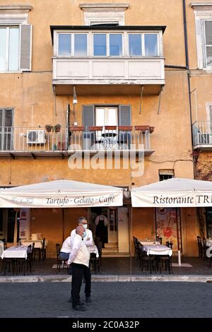 Kellner eines berühmten Restaurants auf der Piazza Navona, warten auf alle Kunden. Leere Tabellen wegen des Covid 19 Coronavirus. Rom zur Zeit von Covid 19. Italien, Europa, Europäische Union, EU. Stockfoto