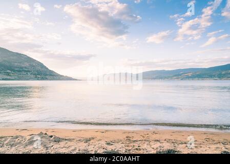 Blick auf den Sonnenuntergang über Okanagan Lake mit Farben, die sich im Wasser spiegeln Stockfoto