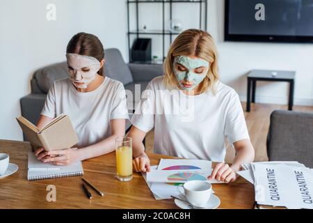 Schwestern im Gesicht maskiert Buch lesen und arbeiten mit Papieren am Tisch Stockfoto