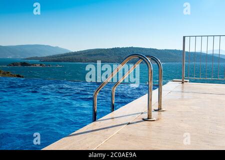 Blick vom Infinity-Pool auf die mediterrane Landschaft mit Ägäis und grünen Hügeln, Bodrum, Türkei Stockfoto