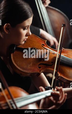 Professionelle Musiker spielen klassische Musik auf dunkler Bühne Stockfoto