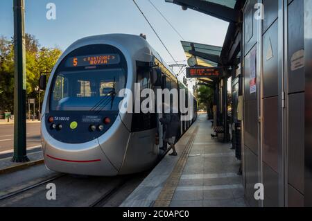 Athen, Attika / Griechenland. Die Straßenbahn der Linie 5 der Stadt Athen an der Haltestelle Syntagma Square. Ältere Frau tritt in die Straßenbahn ein Stockfoto