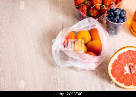 Fruchtkomposition mit Beeren, Grapefruit und Aprikosen auf Holzfläche Stockfoto