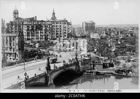 [ Japan der 1920er Jahre - Erdbeben von großem Kanto ] - Verwüstung in Nihonbashi durch das Erdbeben von großem Kanto (Kanto Daishinsai) vom 1. September 1923 (Taisho 12). Im Vordergrund ist die Nihonbashi-Brücke zu sehen. Das Beben, das auf der Richterskala eine geschätzte Größe zwischen 7.9 und 8.4 hatte, verwüstete Tokio, die Hafenstadt Yokohama, die umliegenden Präfekturen Chiba, Kanagawa und Shizuoka und forderte über 140,000 Opfer. Vintage-Postkarte des 20. Jahrhunderts. Stockfoto